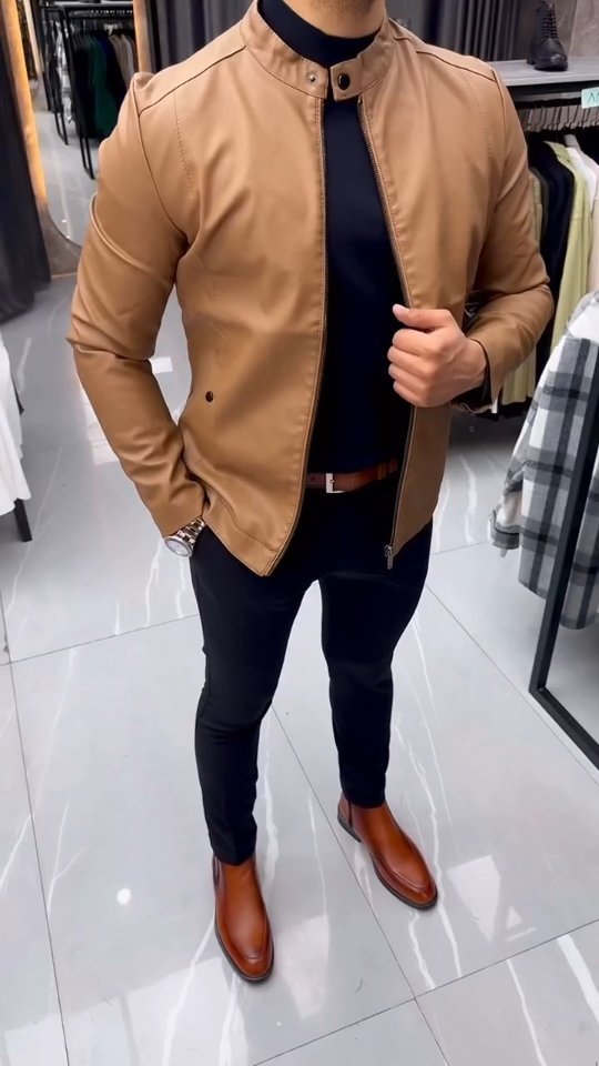Man wearing a tan leather jacket with a dark top, dark trousers and brown leather boots