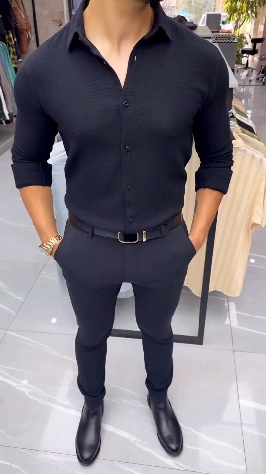 Man wearing a dark navy shirt tucked into black trousers with black leather shoes for a smart casual outfit