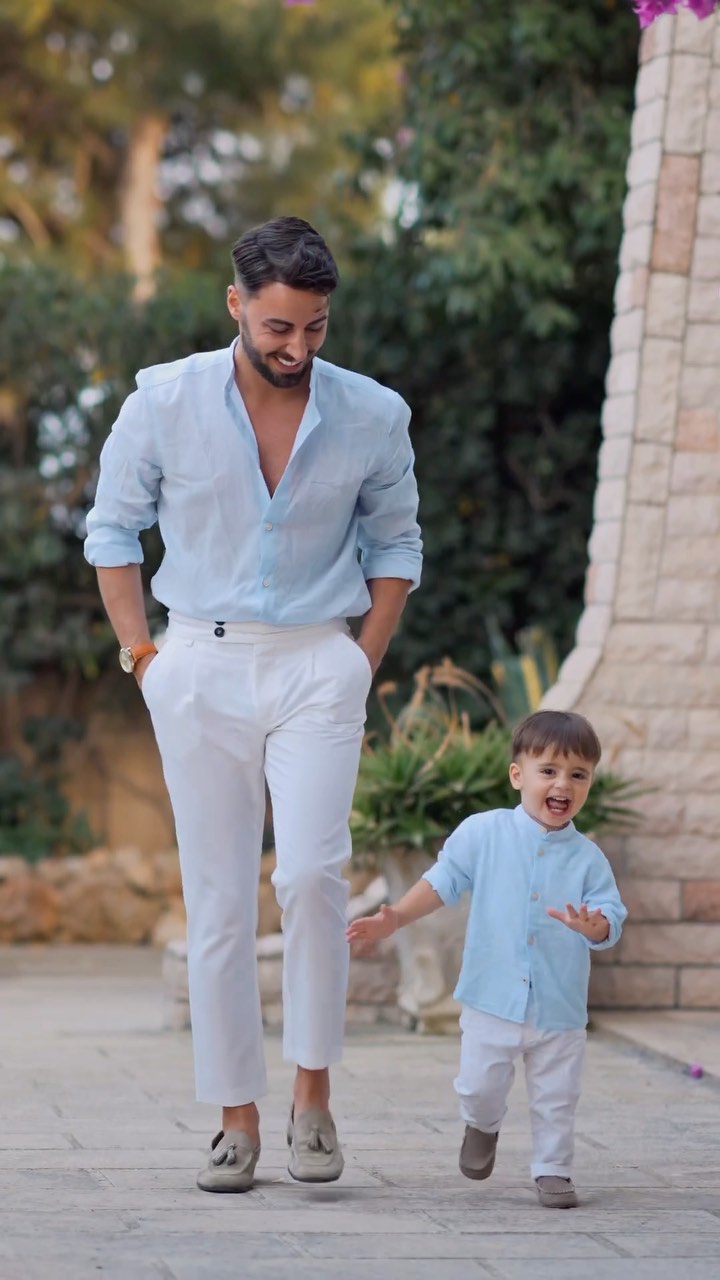 Man wearing a light blue shirt with white trousers and brown loafers