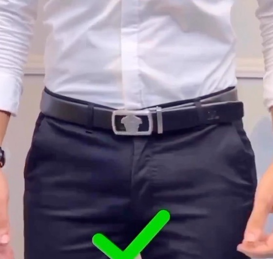 White shirt tucked smoothly into dark trousers with a black leather belt and restrained metal buckle