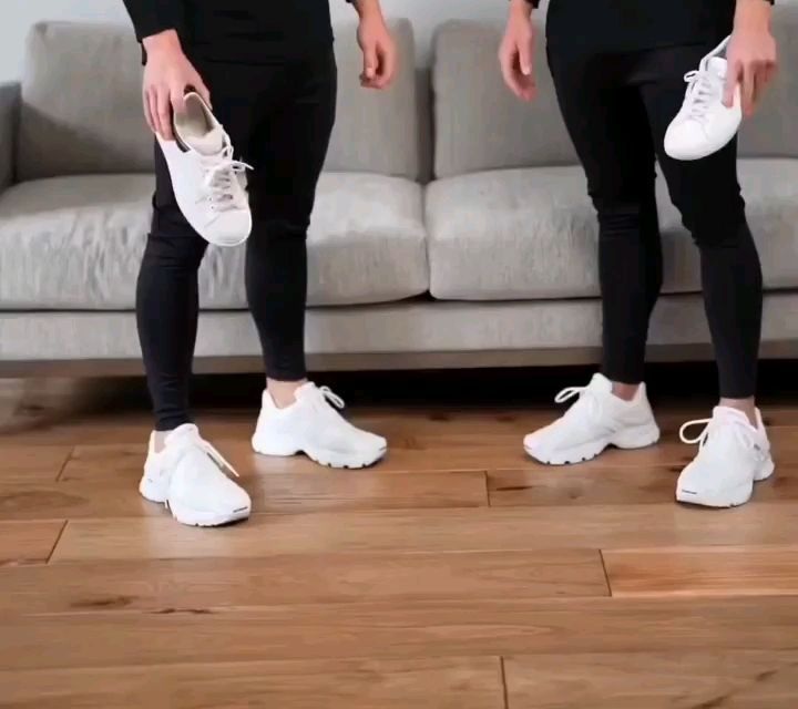 Lower-body view of slim black trousers worn with substantial white athletic sneakers