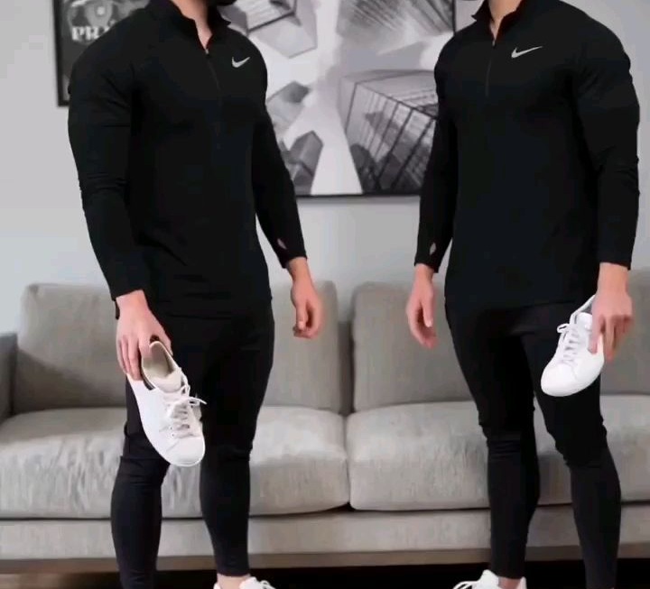 Men holding clean low-profile white sneakers against matching black casual outfits