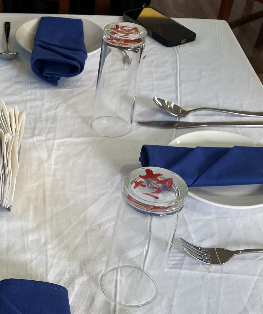 Dining table with a smartphone visible near one place setting