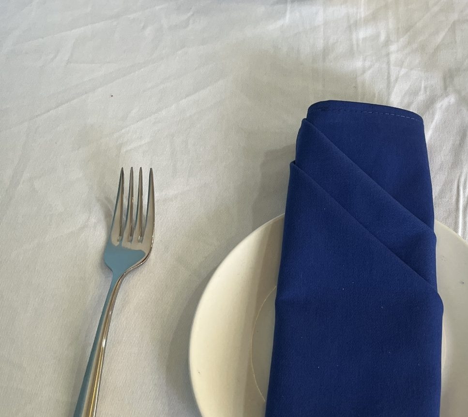 Blue cloth napkin folded on a white plate
