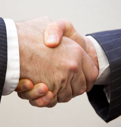 Close crop showing a neutral, vertical handshake with full hand contact