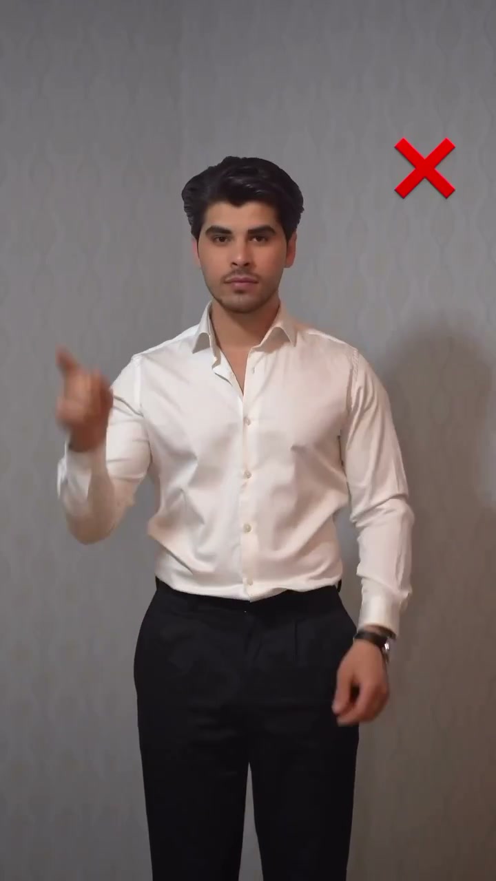 A tucked white shirt bunching and bulging over the waistband of black trousers