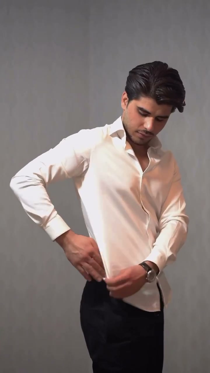 Pinching the excess side fabric of a white shirt at the side seam