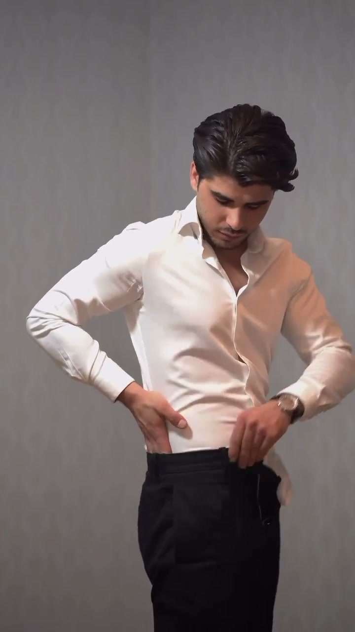 Folding the pinched shirt fabric backwards toward the back of the waist
