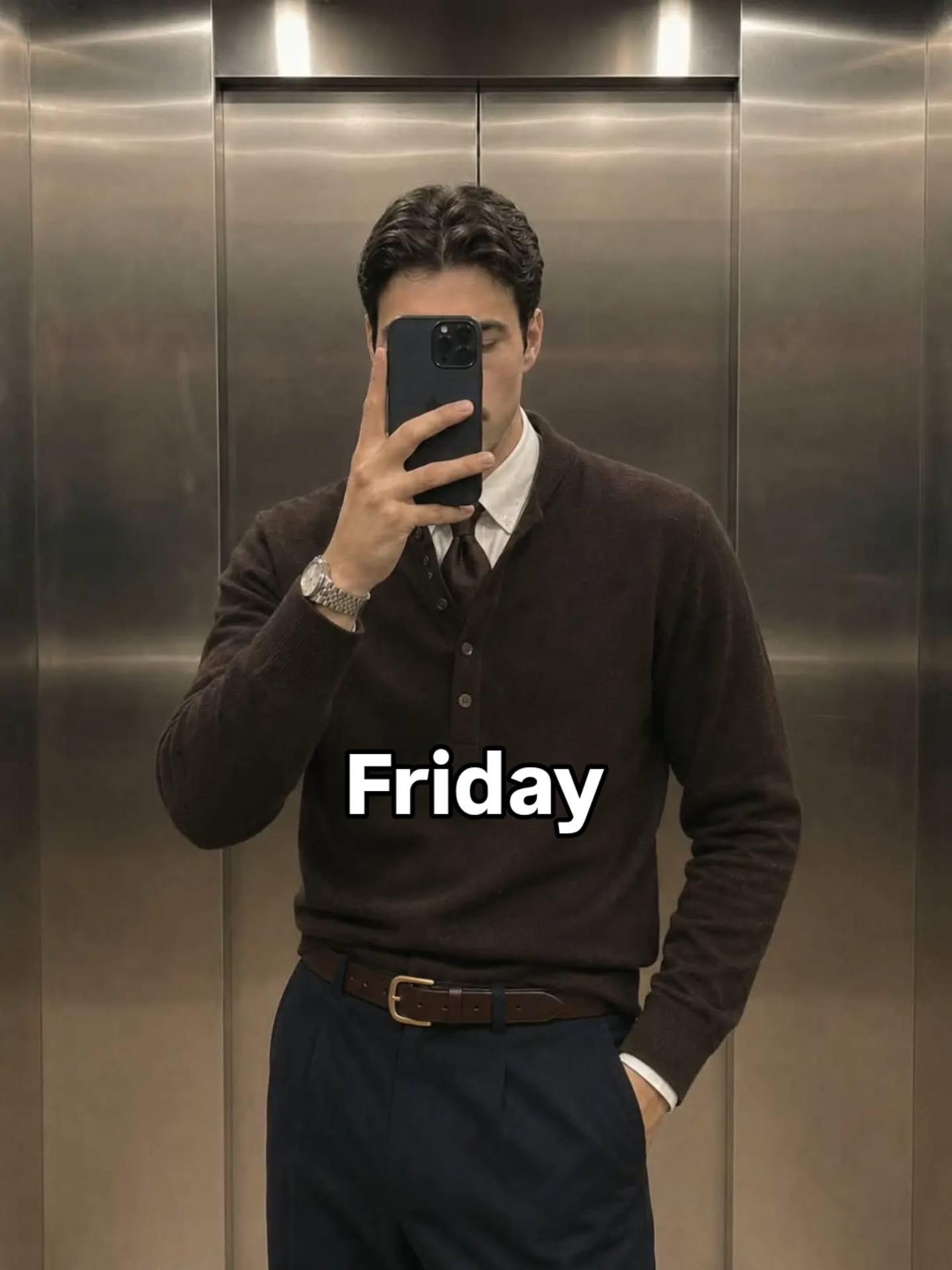 Dark brown cardigan over a white collared shirt and dark tie with navy high-waisted trousers and a brown belt