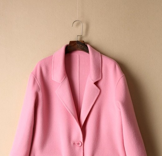 Close-up of a jacket shoulder and hanger, showing how the upper garment is supported at the neckline and shoulder area