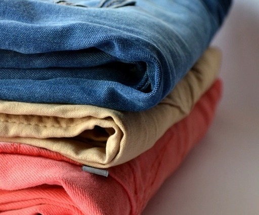 Close-up of denim fabric texture showing the twill weave and natural fading zones